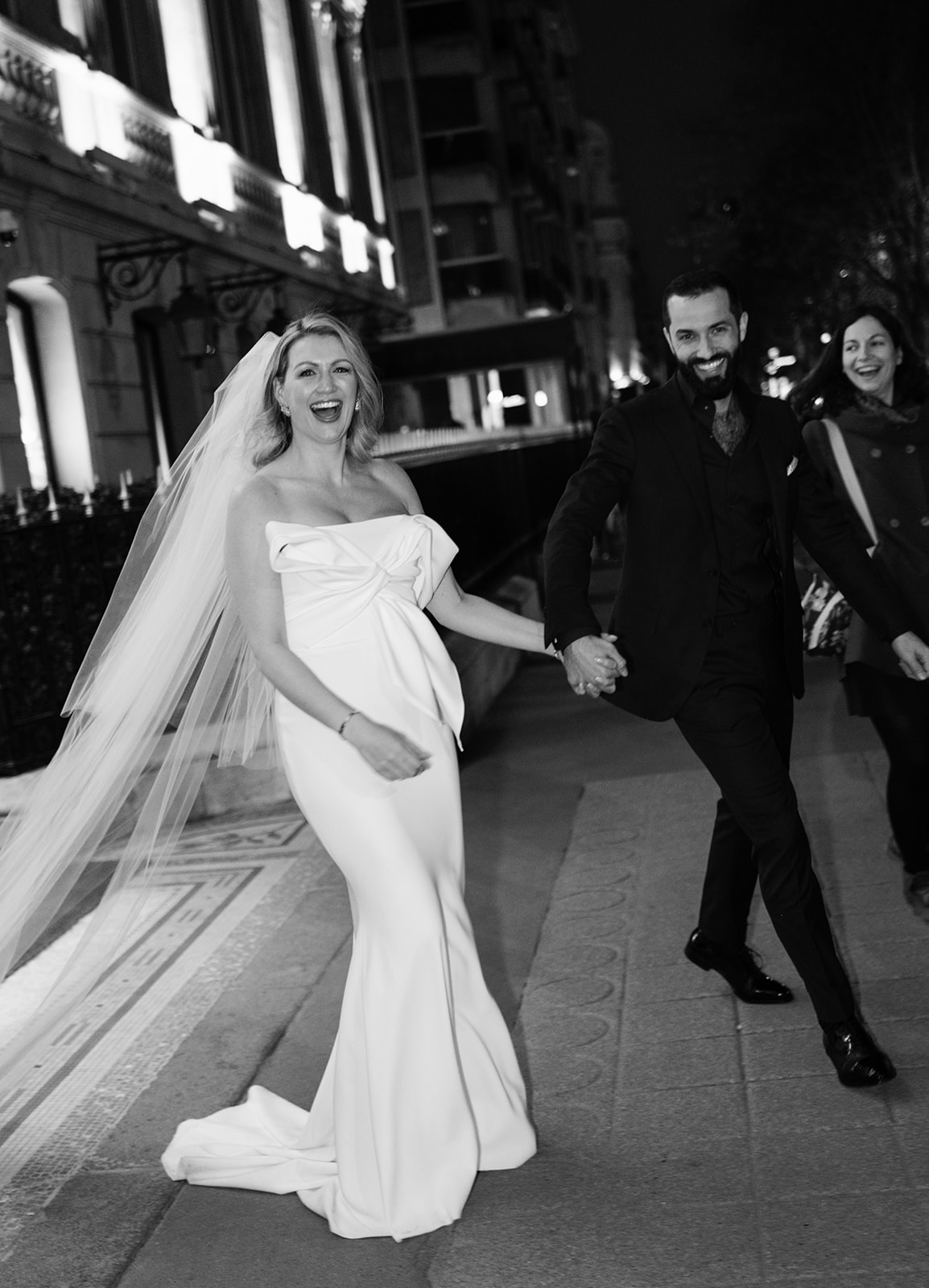 Playful newlyweds running along Avenue Montaigne after their Plaza Athénée wedding